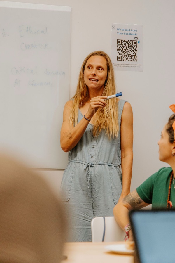 Brooke teaching AI literacy at a whiteboard